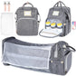 Gray diaper bag with multiple compartments and accessories on a white background